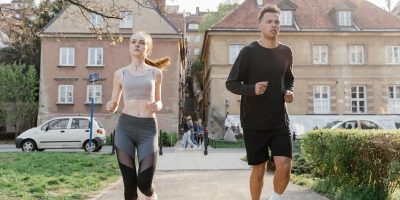 Two young adults jogging on a city path, showcasing an active lifestyle in an urban environment.